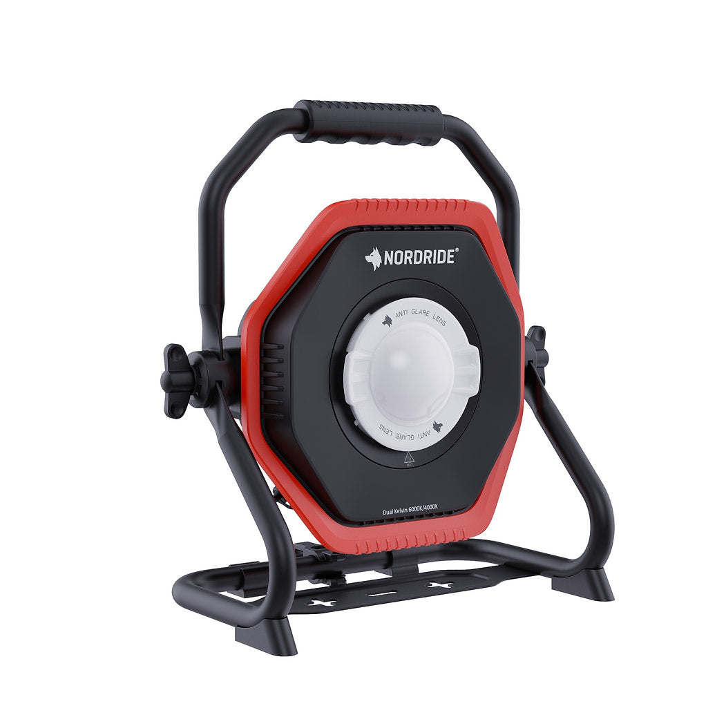 Der Nordride Hochleistungsstrahler Lumos 80W R Dual Kelvin ist eine tragbare Arbeitsleuchte von NORDRIDE, mit rotem und schwarzem sechseckigen Gehäuse, schwarzem Griff/Standfuß, zentralem weißen Dual Kelvin-Drehknopf - perfekt für die Baustellenbeleuchtung.