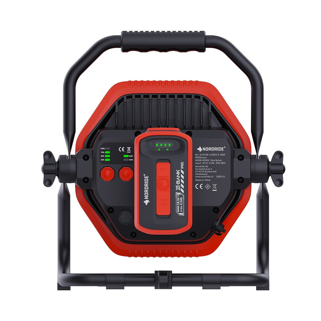 Der Nordride Hochleistungsstrahler Lumos 80W R Dual Kelvin von NORDRIDE verfügt über ein tragbares schwarz-rotes Gehäuse, einen verstellbaren Griff und rückseitige Bedienelemente - ideal für die Beleuchtung von Baustellen.