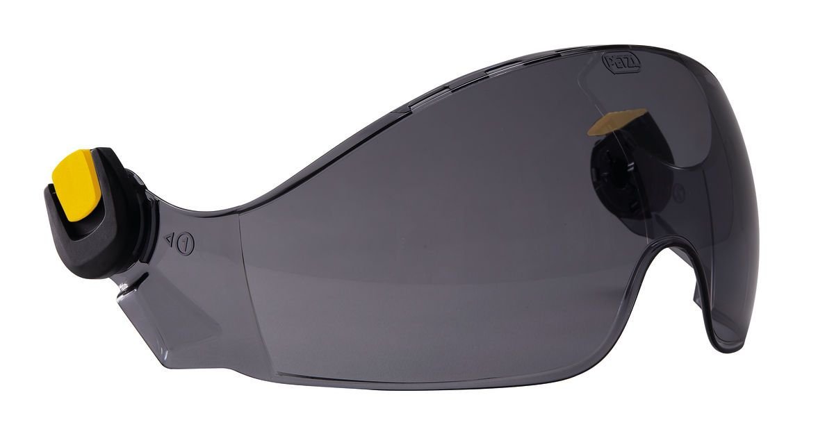 Das PETZL Schutzvisier VIZIR SHADOW ist ein dunkel getöntes Rundumvisier mit gewölbtem Design und gelb-schwarzer Seitenbefestigung, das vollen Augenschutz und Kompatibilität mit anderer Ausrüstung oder Kopfbedeckung bietet.