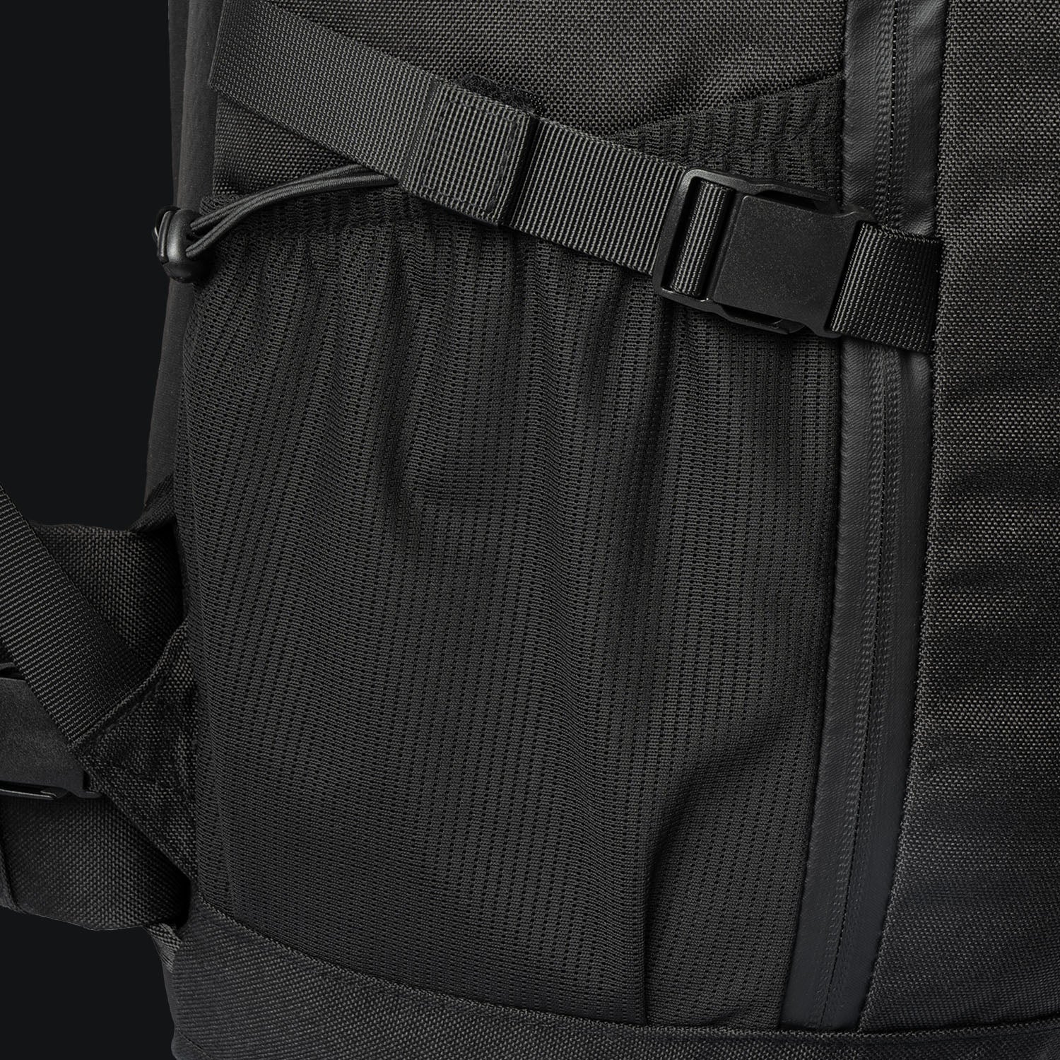Nahaufnahme des STOIRM 40L Tactical Pack GEN2 von STOIRM mit der seitlichen Netztasche, dem verstellbaren Gurt mit Schnalle und dem vertikalen Reißverschluss. Mit strapazierfähigem, strukturiertem Material für Outdoor-Abenteuer gebaut.