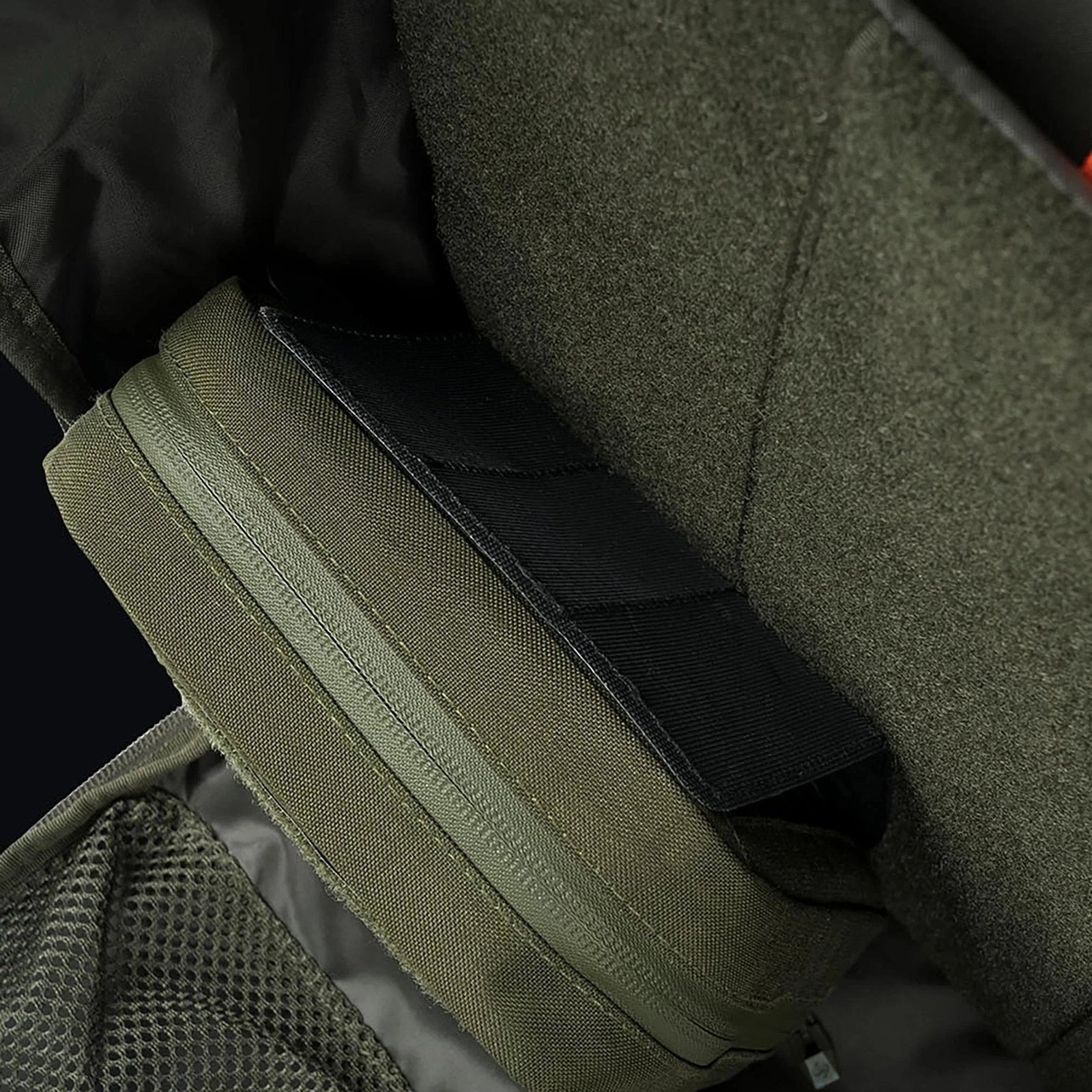 Nahaufnahme eines STOIRM Large Molle Panel in einem olivgrünen Rucksack, mit gepolsterten Fächern, Netztasche und schwarzen Klettverschlüssen zur Sicherung von Gegenständen, vollständig kompatibel mit dem STOIRM Eco-System.