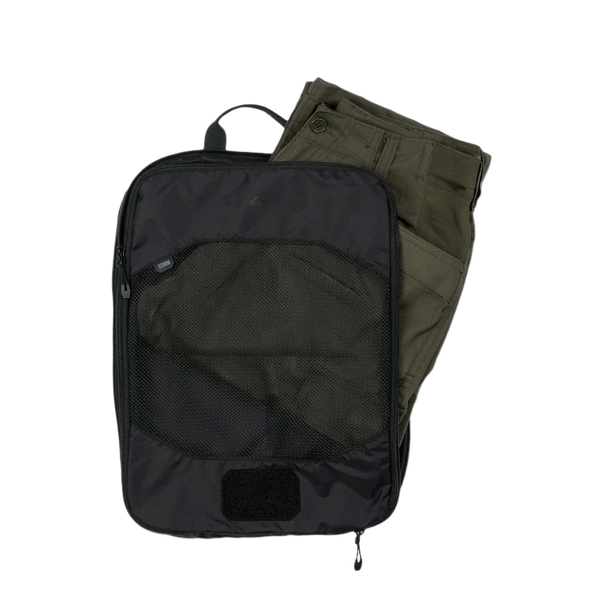 Eine olivgrüne Hose ist teilweise im STOIRM Travel Cube with Laundry Bag von STOIRM verpackt, einem schwarzen Würfel mit Reißverschluss und Netzfront, der vor einem schlichten weißen Hintergrund abgebildet ist.