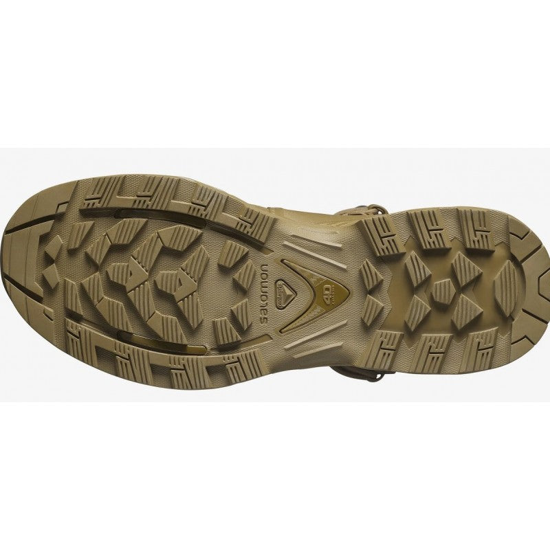 Das Bild zeigt die coyote-braune, robuste Sohle des SALOMON FORCES QUEST 4D FORCES 2 HIGH GTX DE Schuhs, mit tiefem, multidirektionalem Profil für Traktion in unwegsamem Gelände. Das Salomon-Logo erscheint in der Mitte.