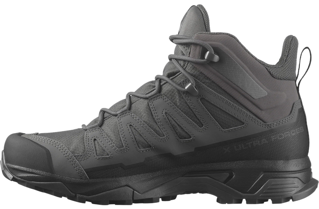 Eine Seitenansicht des SALOMON FORCES X ULTRA FORCES MID GTX - Wolf, eines dunkelgrauen Stiefels mit robuster Sohle, Obermaterial aus Mesh und Synthetik, sicheren Schnürsenkeln, Knöchelstütze und Zuglasche auf der Rückseite, vor einem weißen Hintergrund.