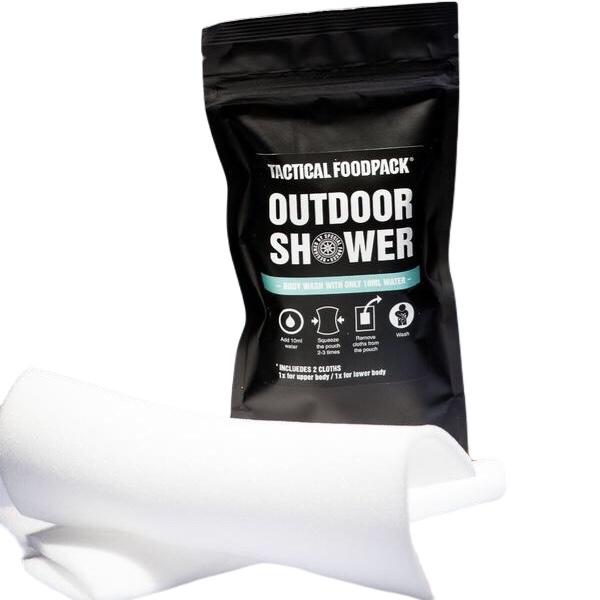 Das schwarze TACTICAL FOODPACK Tactical Foodpack Outdoor Shower Pack steht aufrecht neben einem aufgerollten weißen Tuch. Es enthält ein hautfreundliches Körperwaschmittel, das nur Wasser benötigt, und enthält zwei Tücher für eine einfache Anwendung.