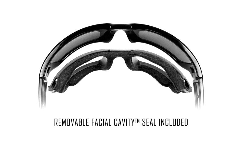 Eine WILEY X Schutzbrille GRAVITY Sonnenbrille mit einem abnehmbaren Schaumstoff Facial Cavity™ Seal, der unterhalb des Rahmens abgetrennt ist. Der Text lautet: Removable Facial Cavity™ Seal Included.