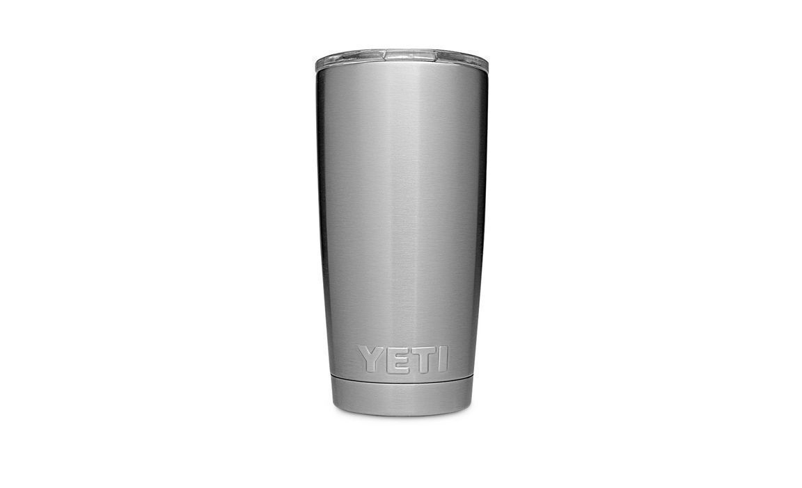 Der YETI® Becher Rambler 20 Oz - Edelstahl steht aufrecht mit einem klaren Kunststoffdeckel auf einem schlichten weißen Hintergrund. Das YETI-Logo ist in der Nähe des Bodens des Bechers eingeprägt.
