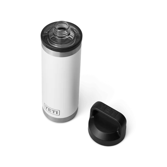Eine weiße YETI® Flasche Rambler 18 Oz mit doppelwandiger Vakuumisolierung steht aufrechtem weißen Hintergrund, der schwarze Chug Cap Deckel befindet sich daneben.