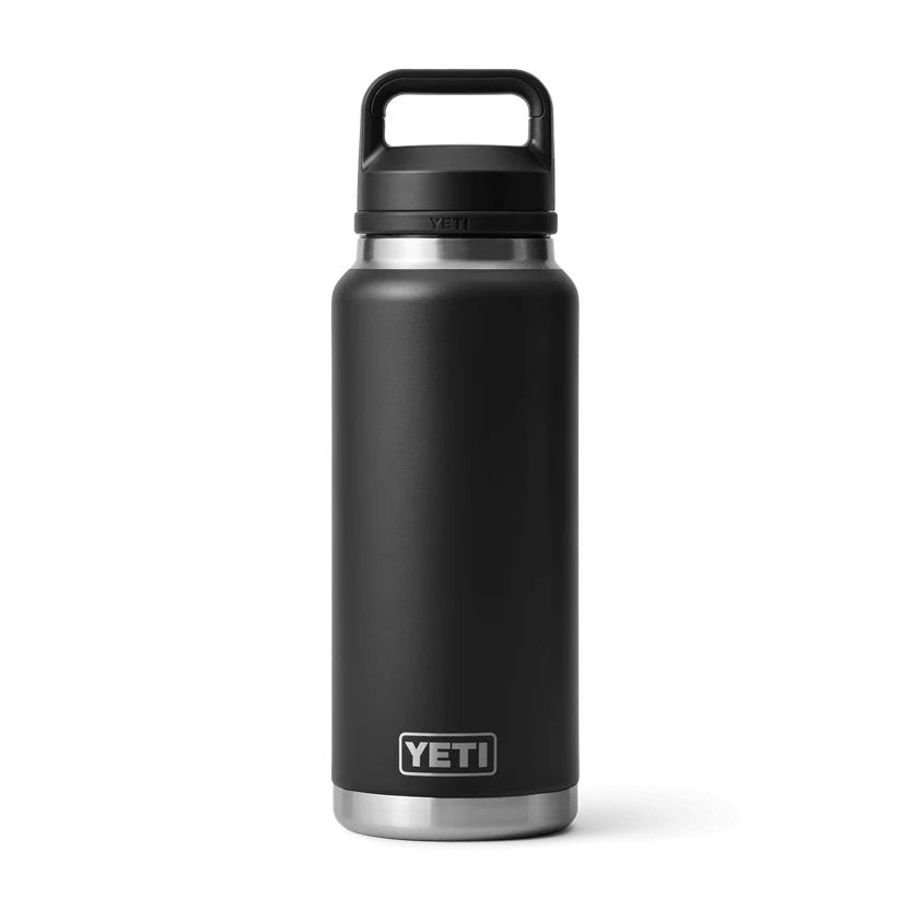 Die YETI® Flasche Rambler 36 Oz - Black aus Edelstahl steht aufrecht vor weißem Hintergrund; die spülmaschinenfeste Flasche hat einen Henkel am Deckel, einen silbernen Boden und das YETI Logo nahe dem Boden.