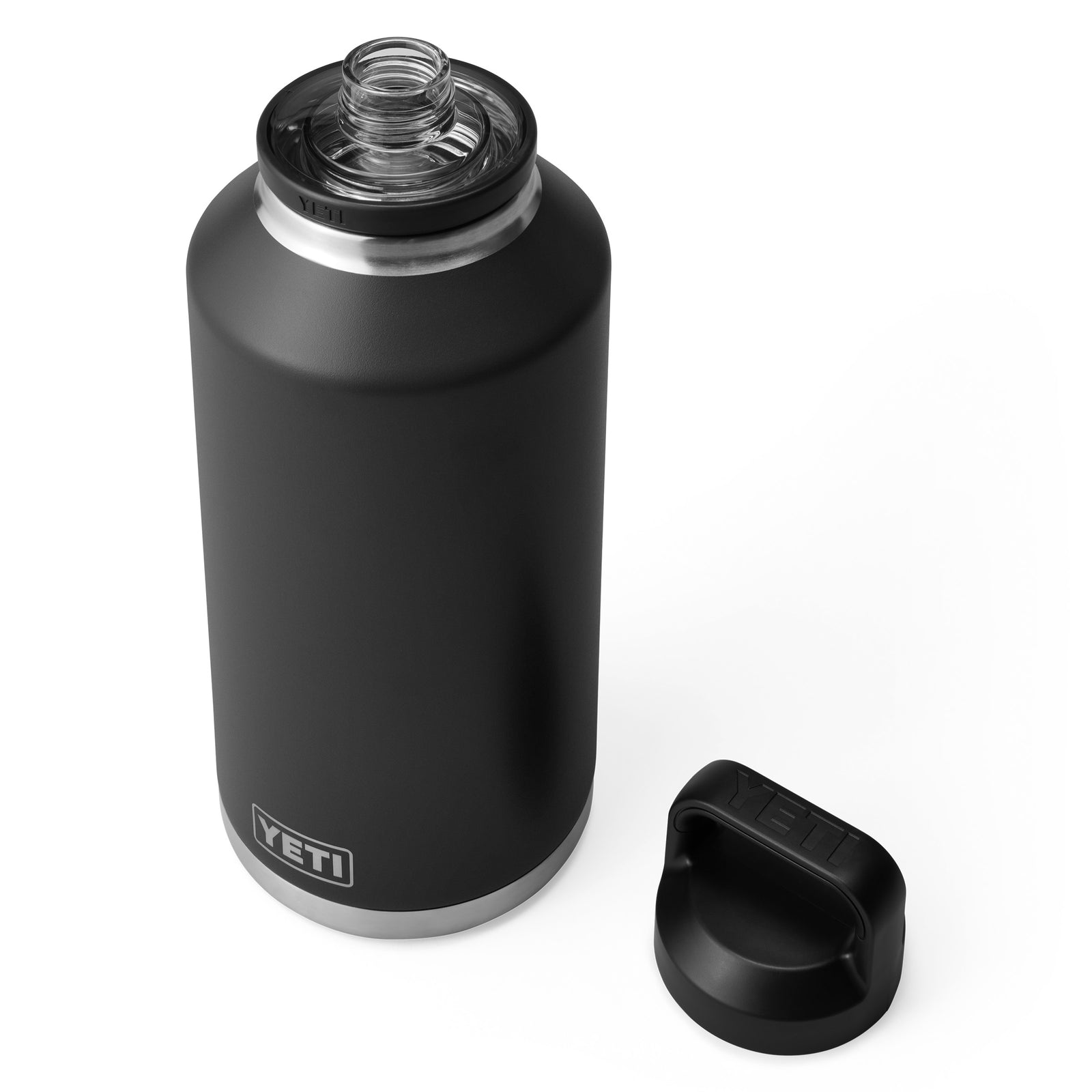 Eine YETI® Flasche Rambler 64 OZ - Black steht aufrecht und zeigt ihr mattes Finish, die doppelwandige Vakuumisolierung und die Weithalsöffnung. Der Deckel liegt daneben und hebt die Edelstahlakzente an der Ober- und Unterseite hervor.