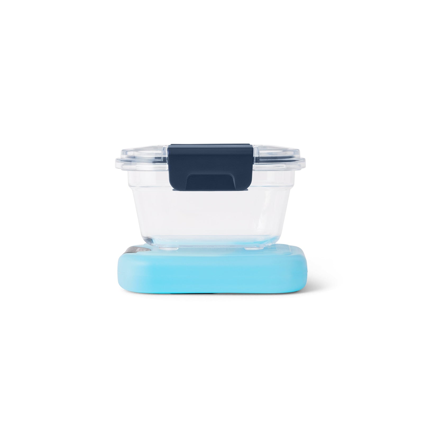 Der YETI® Food Storage Small von YETI besteht aus einem klaren, BPA-freien Behälter mit dunkelblauem Verschluss und hellblauem Boden. Diese auslaufsichere Lösung zur Aufbewahrung von Lebensmitteln hält den Inhalt frisch und sicher und wird vor einem weißen Hintergrund präsentiert.