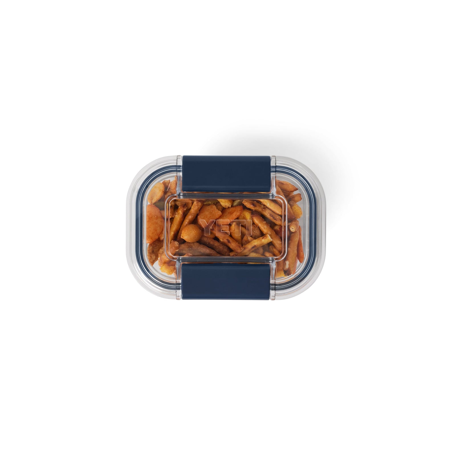 Ein klarer, rechteckiger YETI® Food Storage Small Behälter mit dunkelblauem, auslaufsicherem Schnappdeckel, gefüllt mit verschiedenen getrockneten Pilzen, von oben gesehen auf weißem Hintergrund. BPA-frei für die sichere Aufbewahrung von Lebensmitteln. Marke: YETI.