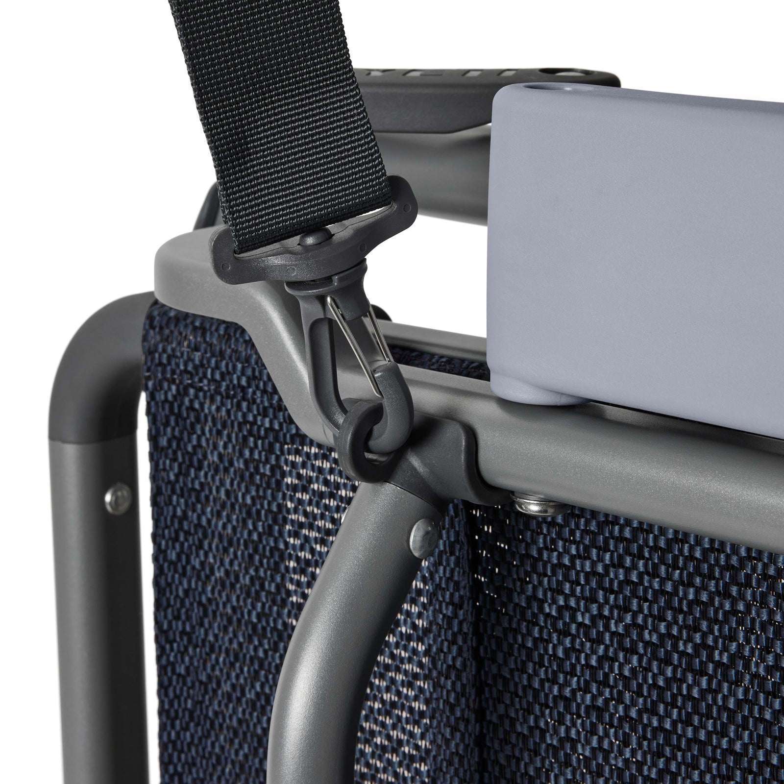 Nahaufnahme eines YETI® Hondo Beach Chair - Navy mit einem stabilen Metallrahmen, einem Sitz aus gewebtem Stoff, einer gepolsterten Kopfstütze und einem schwarzen Gurt, der an der Oberseite befestigt ist.