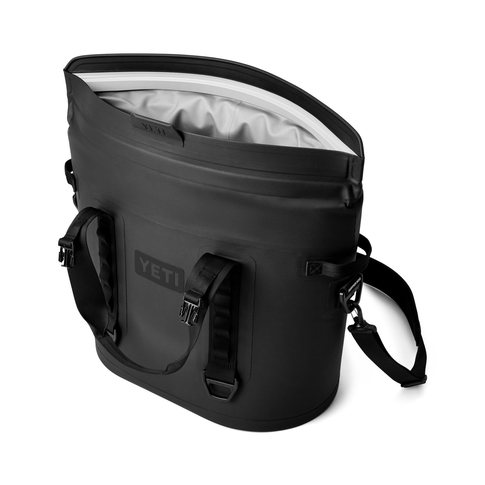 Die YETI® Hopper M30 Soft Cooler in Schwarz hat einen weit geöffneten Deckel, ein weißes Innenfutter, robuste Seitengriffe und einen verstellbaren Schultergurt.