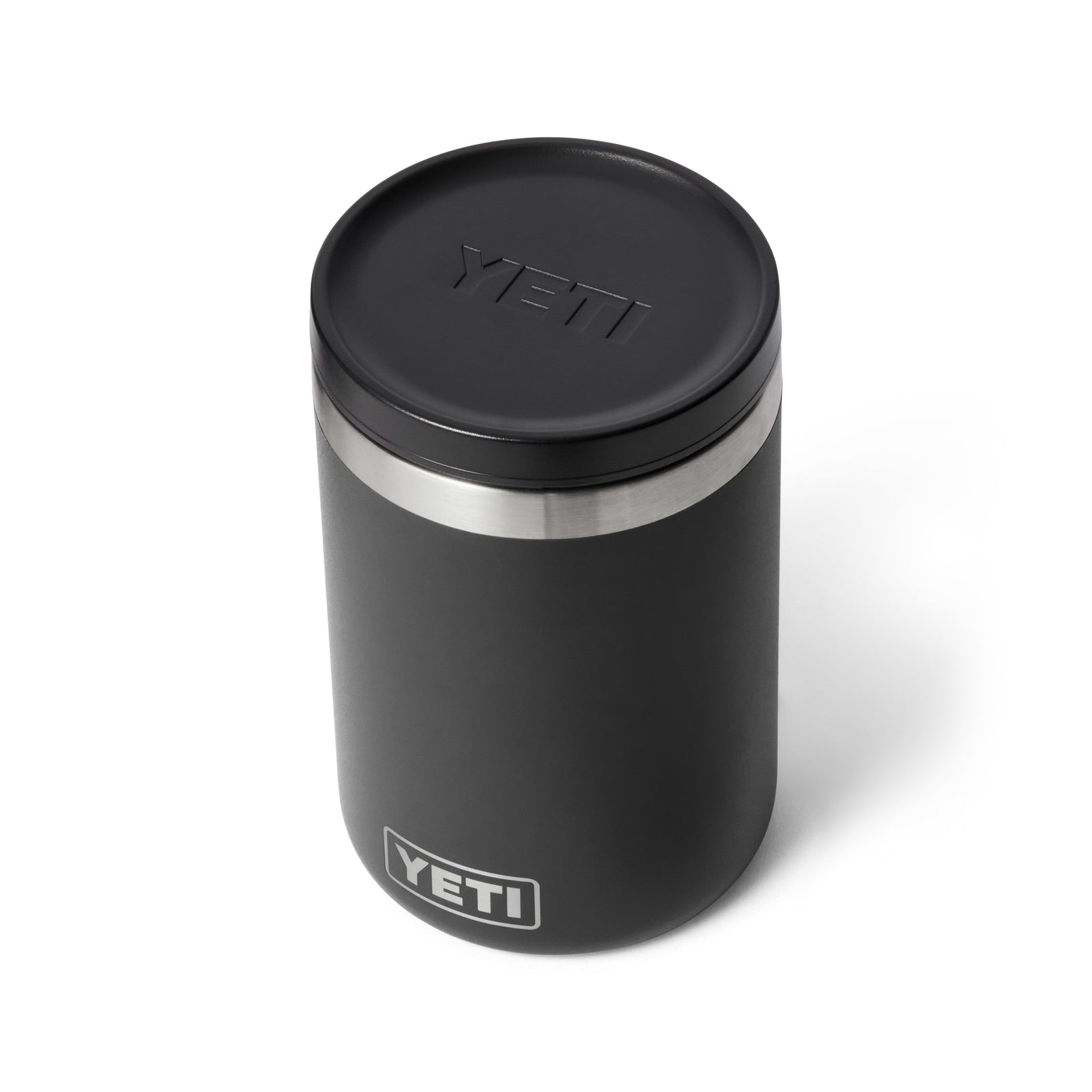 Der YETI® Isolierter Essensbehälter Rambler 16 oz in Schwarz zeichnet sich durch ein robustes, vakuumisoliertes Design mit Edelstahlakzenten und einem geprägten YETI-Logo auf dem Deckel aus, das sich vor einem weißen Hintergrund präsentiert.