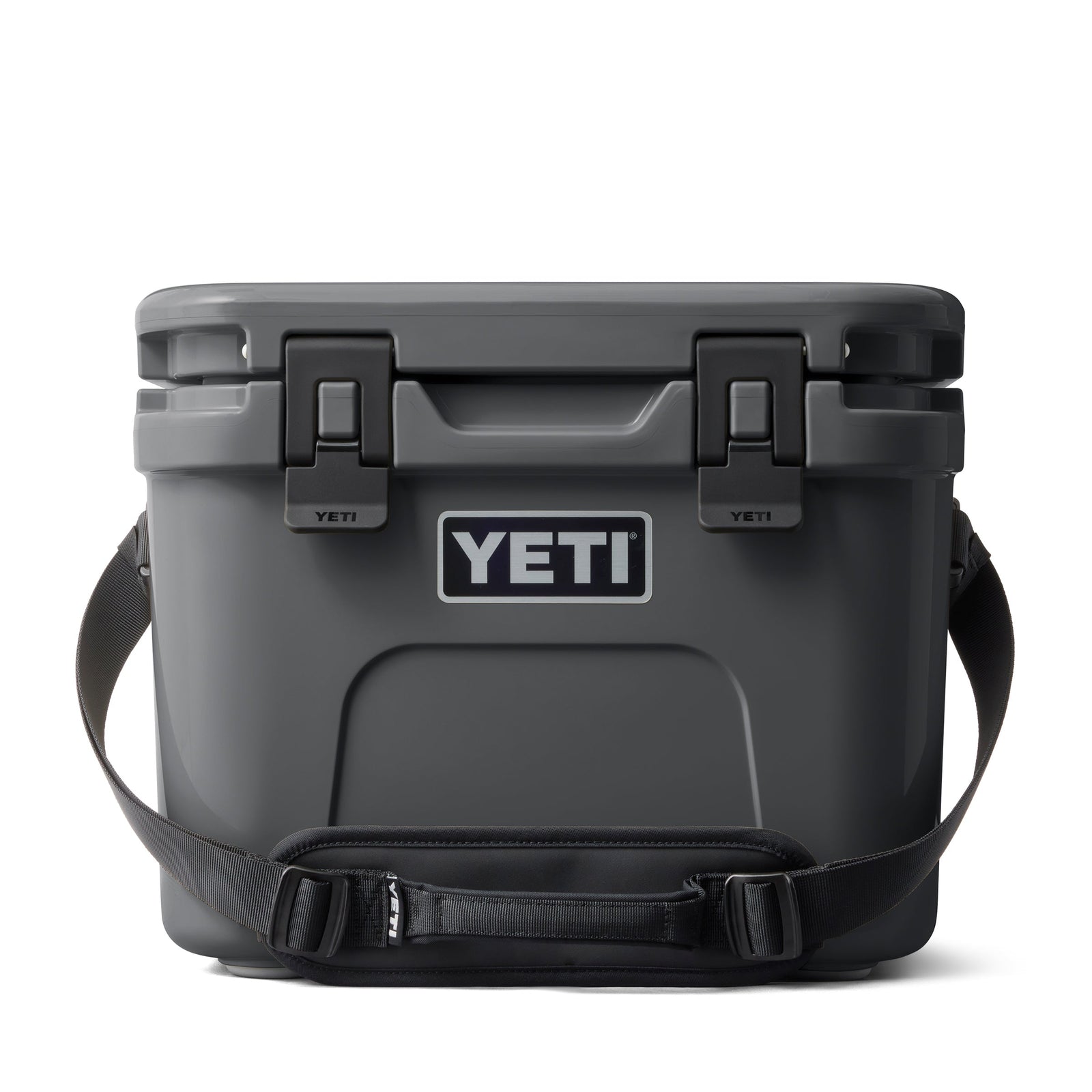 Die YETI® Kühlbox Roadie 15 in Anthrazit mit Trageriemen und Sicherheitsverschlüssen ist auf weißem Hintergrund zu sehen. Das kultige YETI-Logo prangt auf der Vorderseite.