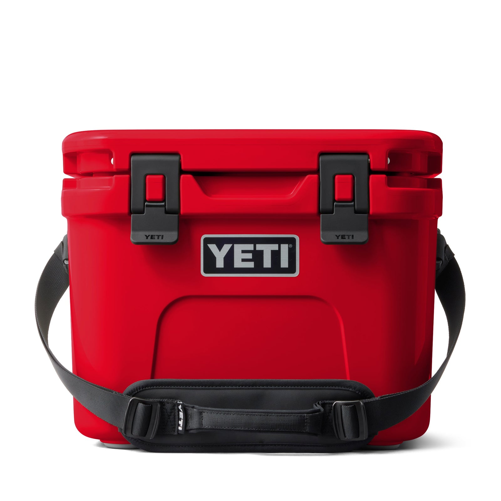 Die YETI® Kühlbox Roadie 15 - Rescue Red, mit schwarzem Griff und seitlichen Gurten, hat ein markantes YETI-Logo auf der Vorderseite. Die Kühlbox ist geschlossen und vor einem weißen Hintergrund abgebildet.