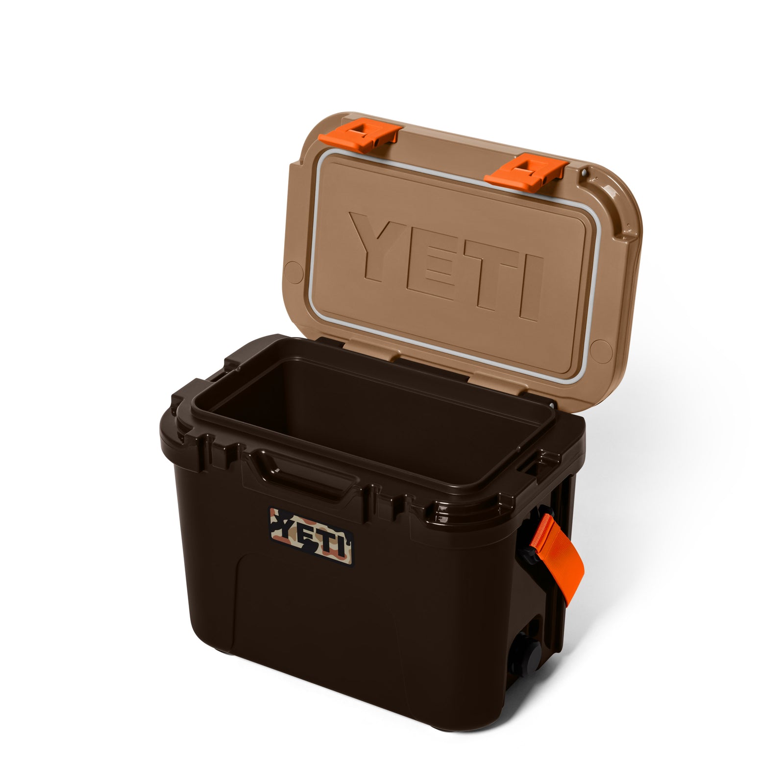 Eine YETI® Kühlbox Roadie 15 in Wetlands Camo mit hellbraunem Deckel, orangefarbenen Verschlüssen und geprägtem YETI-Logo wird geöffnet vor einem weißen Hintergrund gezeigt.