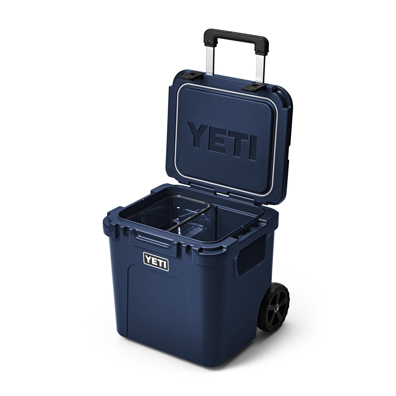 Die YETI® Kühlbox Roadie 48 - Navy von YETI ist mit geöffnetem Deckel abgebildet und zeigt einen leeren Innenraum mit herausnehmbarer Trennwand, sowie PermaFrost Isolierung, Räder und Teleskopgriff.