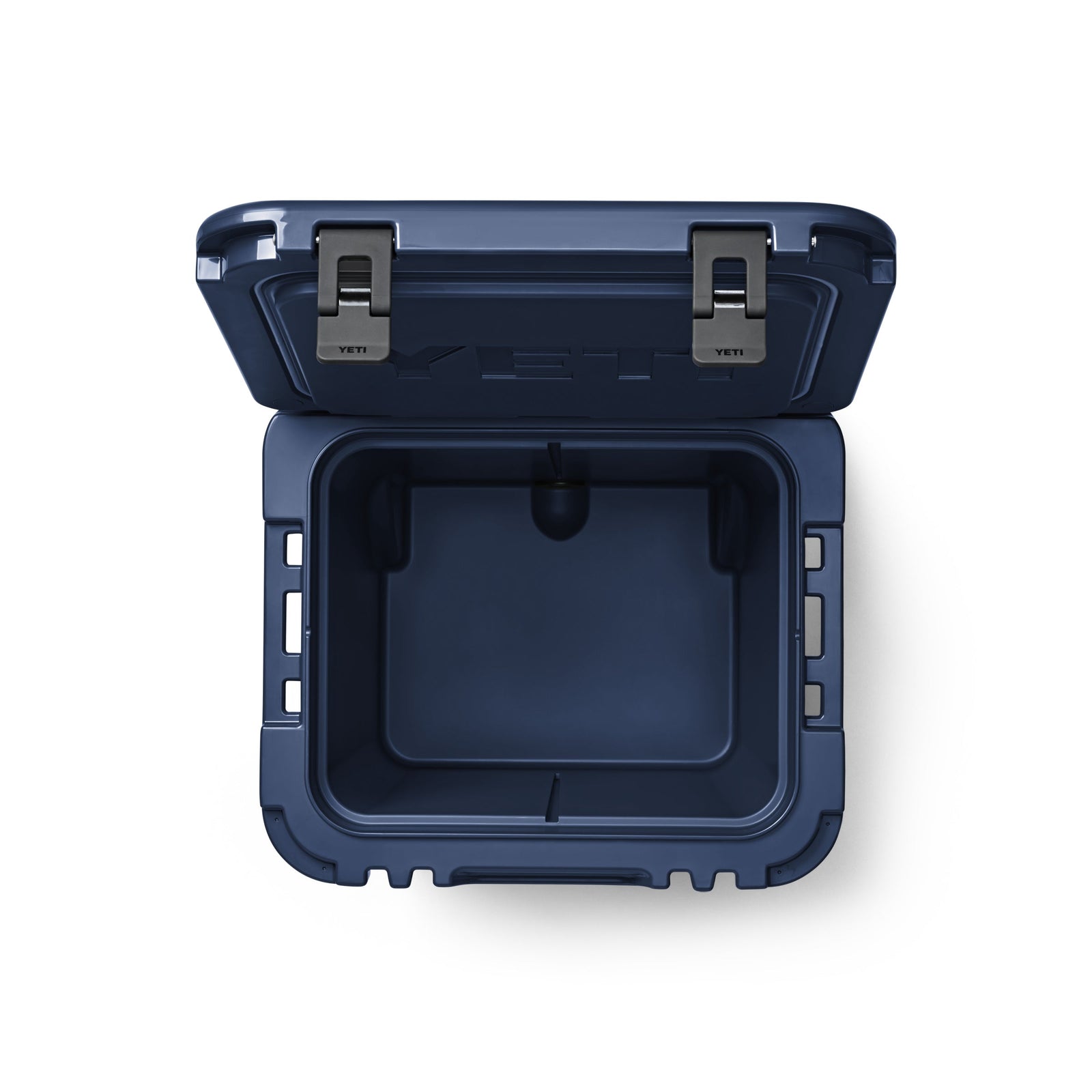 Blick von oben auf die geöffnete, leere YETI® Kühlbox Roadie 48 - Navy mit zwei Metallverschlüssen und dicker PermaFrost™-Isolierung, vor weißem Hintergrund.