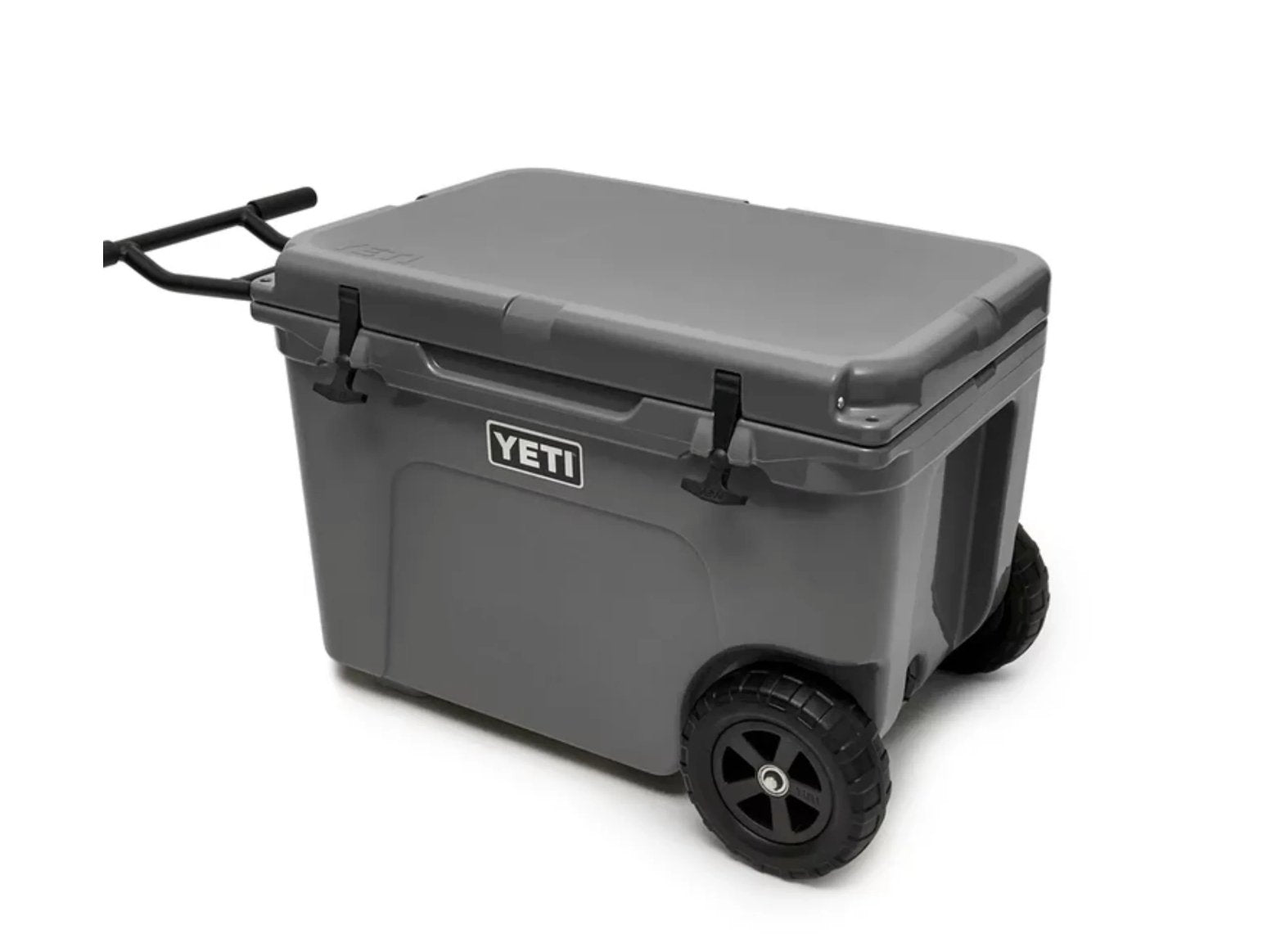 Die YETI® Kühlbox Tundra Haul - Charcoal ist mit schwarzen Rädern und einem schwarzen Zuggriff auf weißem Hintergrund abgebildet. Die robuste, rollbare Kühlbox trägt das kultige YETI-Logo auf der Vorderseite.