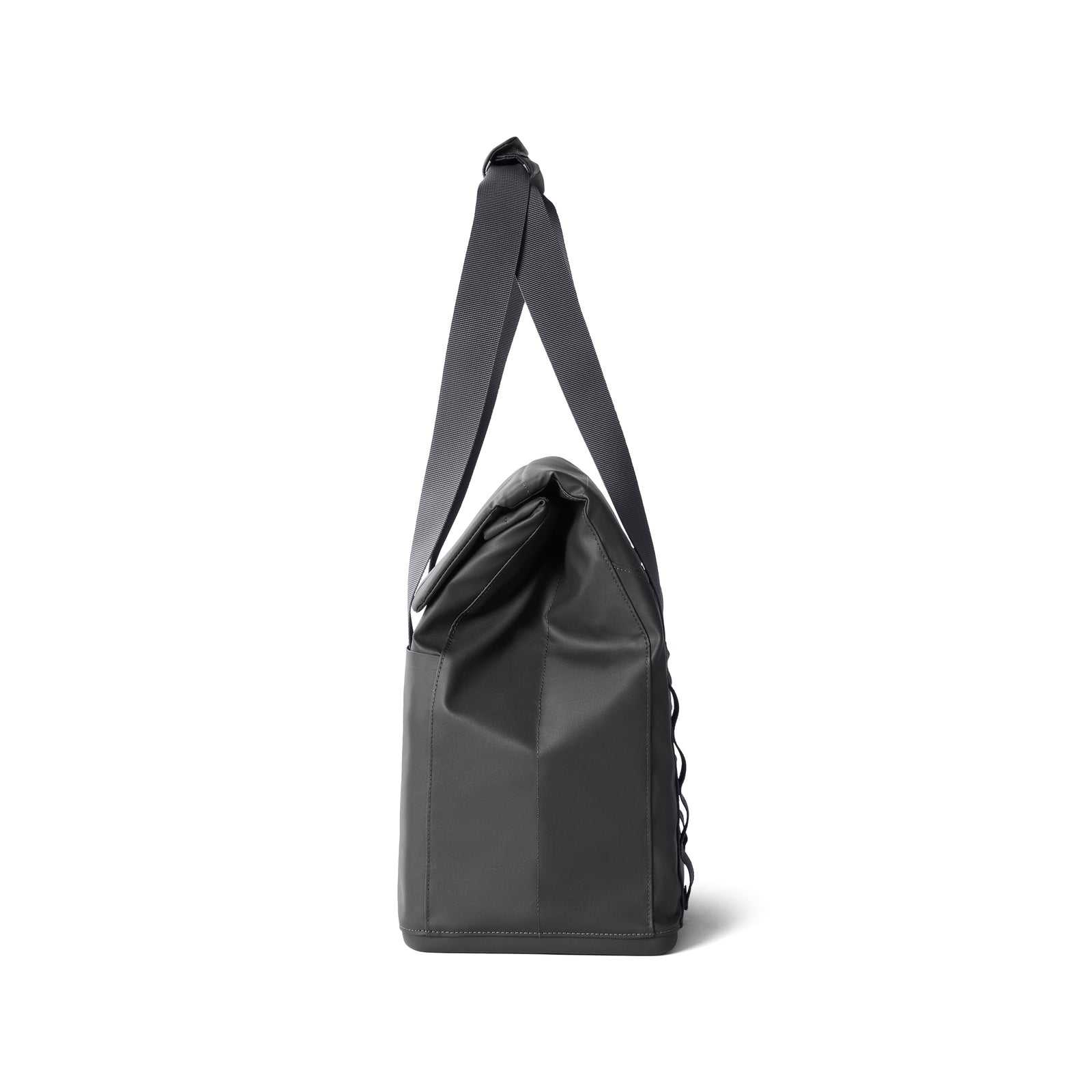 Seitenansicht der YETI® Kühltasche Daytrip Lunch Bag 14L in Charcoal mit Coldcell Flex Isolierung, einem langen verstellbaren Gurt und gefaltetem Deckel, dargestellt vor einem schlichten weißen Hintergrund.