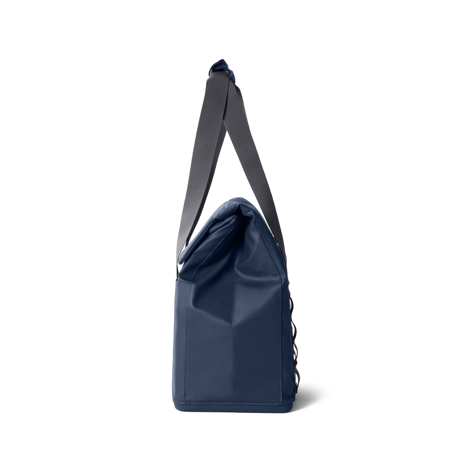 Eine Seitenansicht der YETI® Kühltasche Daytrip Lunch Bag 14L in Navy, einer dunkelblauen, rechteckigen Tasche von YETI mit einem grauen, verstellbaren Schultergurt und Coldcell Flex Isolierung, dargestellt vor einem schlichten weißen Hintergrund.