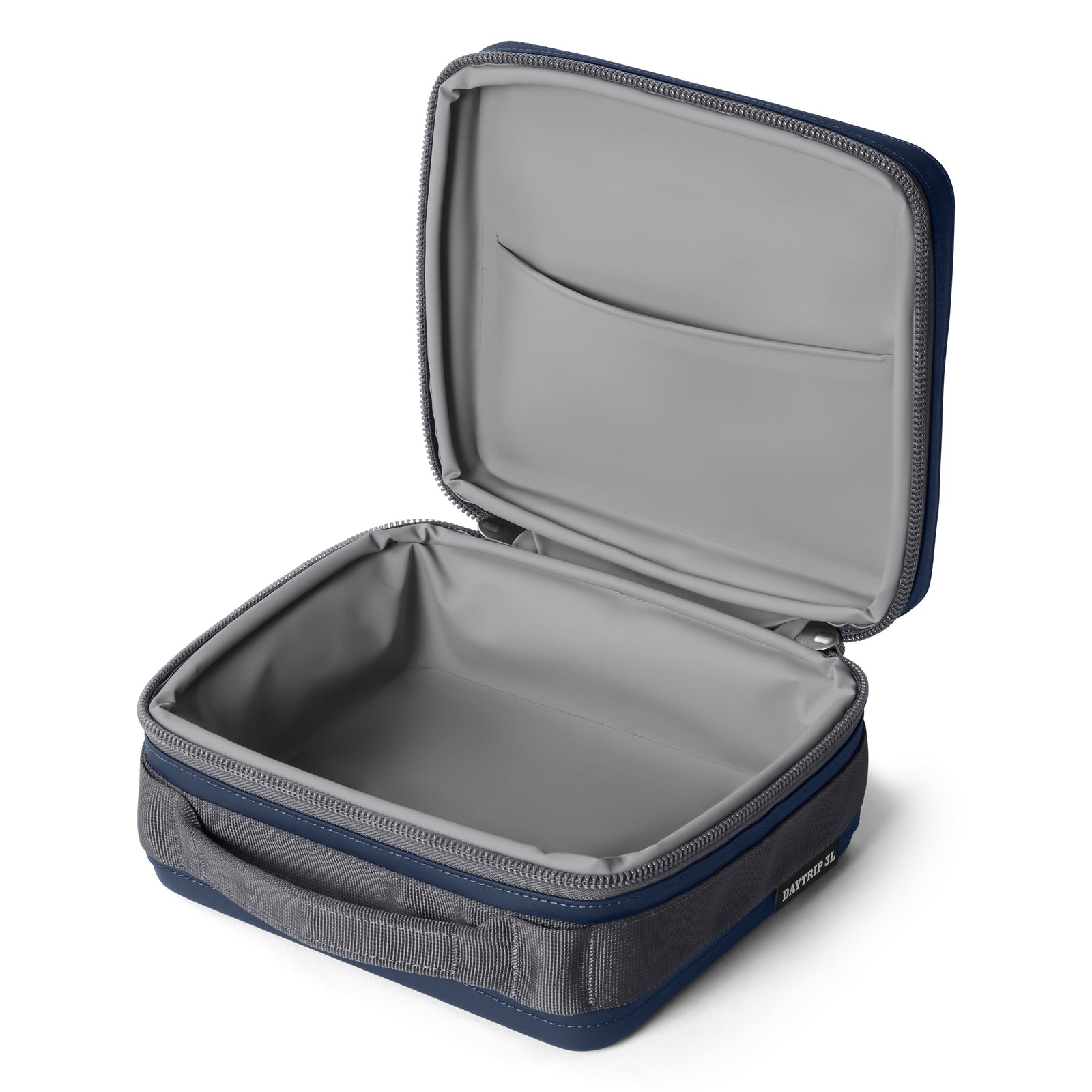 Die YETI® Kühltasche Daytrip Lunch Box 3L in Navy hat ein rechteckiges, weiches Design mit einem Reißverschluss, einer grauen Innentasche, einem Seitengriff und einer Kühlhaltefunktion, um Mahlzeiten unterwegs frisch zu halten.