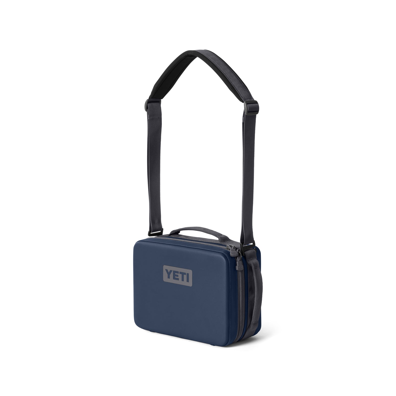 Die YETI® Kühltasche Daytrip Lunch Box 5L in navy mit rechteckiger Form, Reißverschluss und verstellbarem schwarzen Schultergurt steht aufrecht vor weißem Hintergrund.