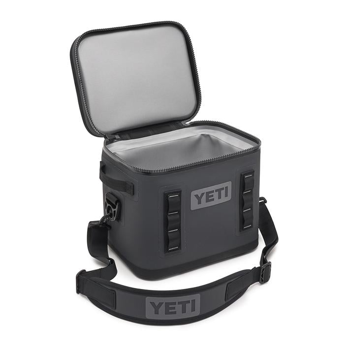 Eine marineblaue YETI® Kühltasche Hopper Flip® 12 mit einem geöffneten Reißverschluss, der den Blick auf das isolierte Innere freigibt. Diese YETI Kühltasche verfügt über einen Schultergurt und seitliche Griffe für einfaches Tragen.