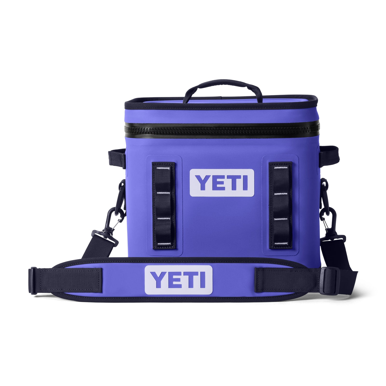 Die YETI® Kühltasche Hopper Flip® 12 in Ultramarine Violett verfügt über einen wasserdichten Reißverschluss, einen Tragegriff oben, einen verstellbaren Schultergurt, ein YETI-Logo auf der Vorderseite, schwarze Akzente und MagShield-Verschlussriemen.