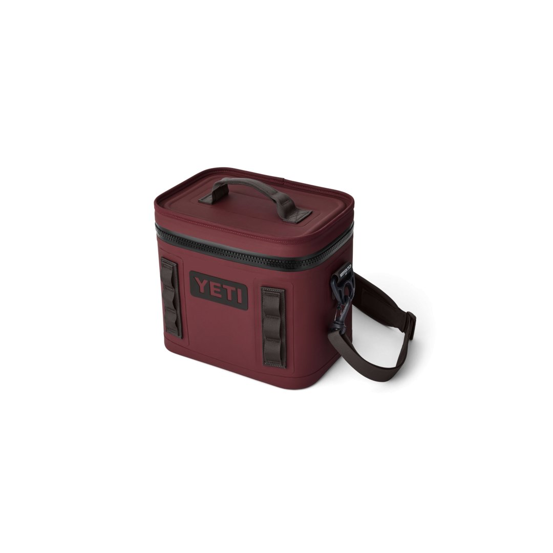 Eine YETI® Kühltasche Hopper Flip® 8 - Wild Vine Red mit schwarzem Reißverschluss, oberem Griff und verstellbarem Schultergurt wird vor einem schlichten weißen Hintergrund gezeigt.