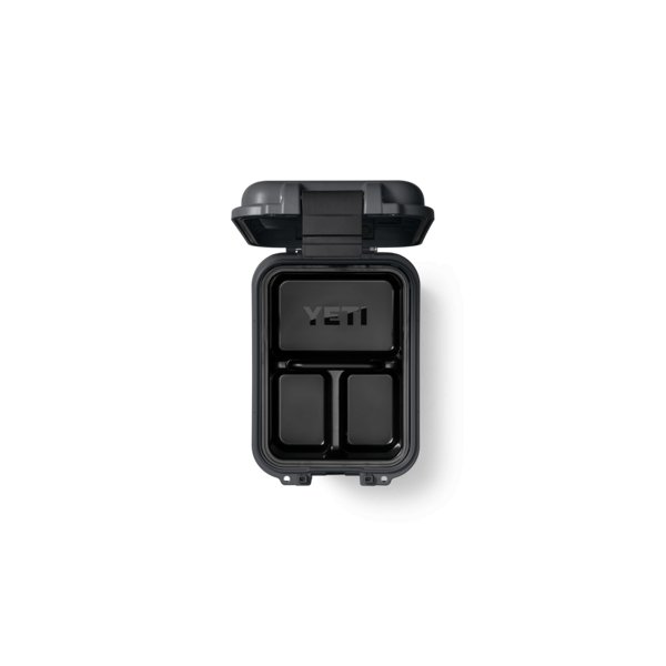 Eine anthrazitfarbene, rechteckige YETI® LoadOut GoBox 15 mit aufklappbarem Deckel, der drei Innenfächer und das YETI-Logo auf dem Innendeckel zeigt; robust und wasserdicht.