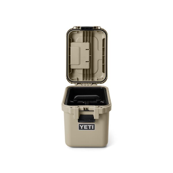 Eine YETI® LoadOut GoBox 15 - Tan wird aufrecht und mit einem schwarzen Riegel geöffnet gezeigt, der ihr leeres Inneres offenbart. Der Klappdeckel befindet sich auf der Rückseite, und das YETI-Logo ist auf der Vorderseite der Box zu sehen.