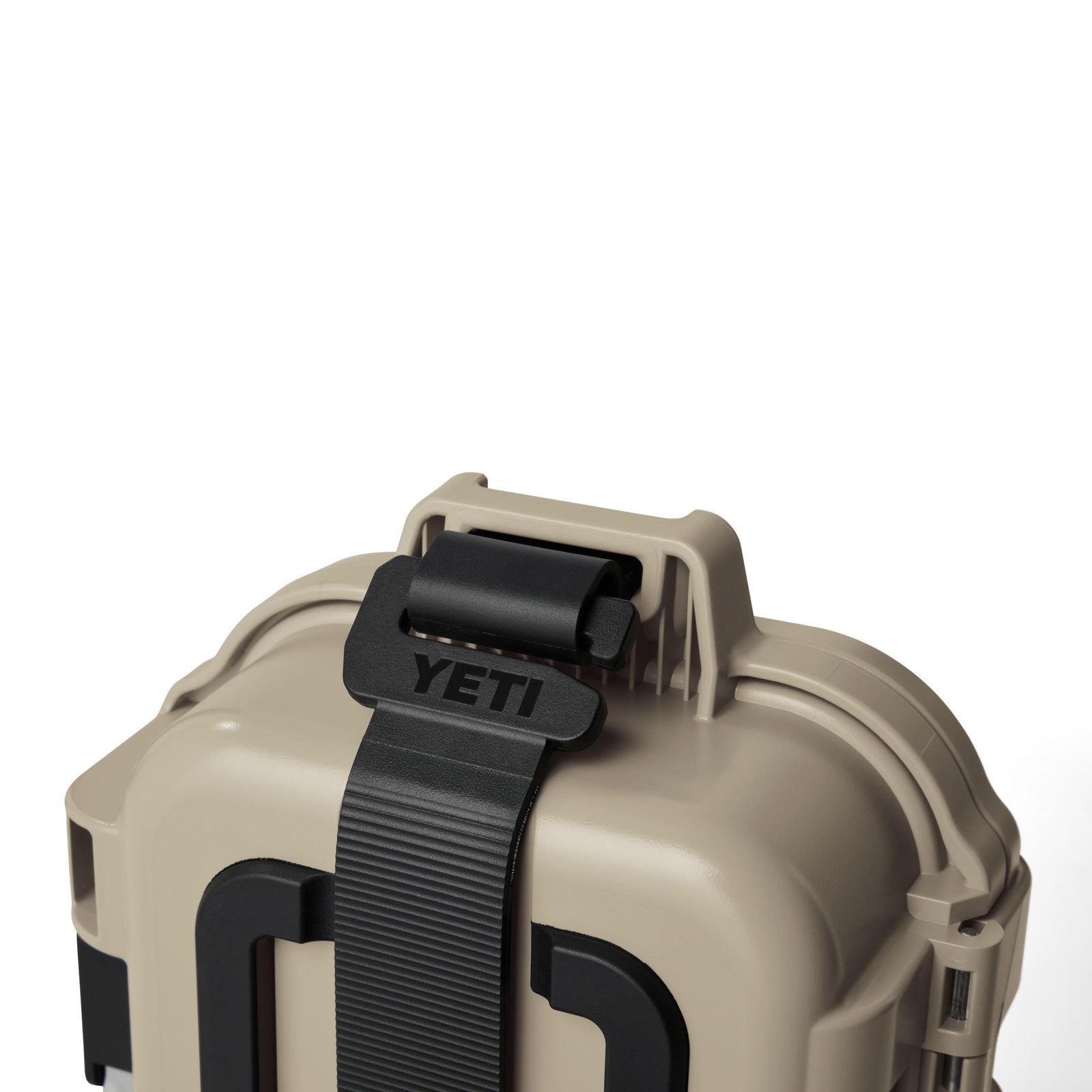 Nahaufnahme der YETI® LoadOut GoBox 1 Ausrüstungsbox - Tan mit schwarzem Gurt und Verschluss, mit dem YETI-Markennamen auf dem Gurt. Diese robuste Box ist vor einem schlichten weißen Hintergrund fotografiert.