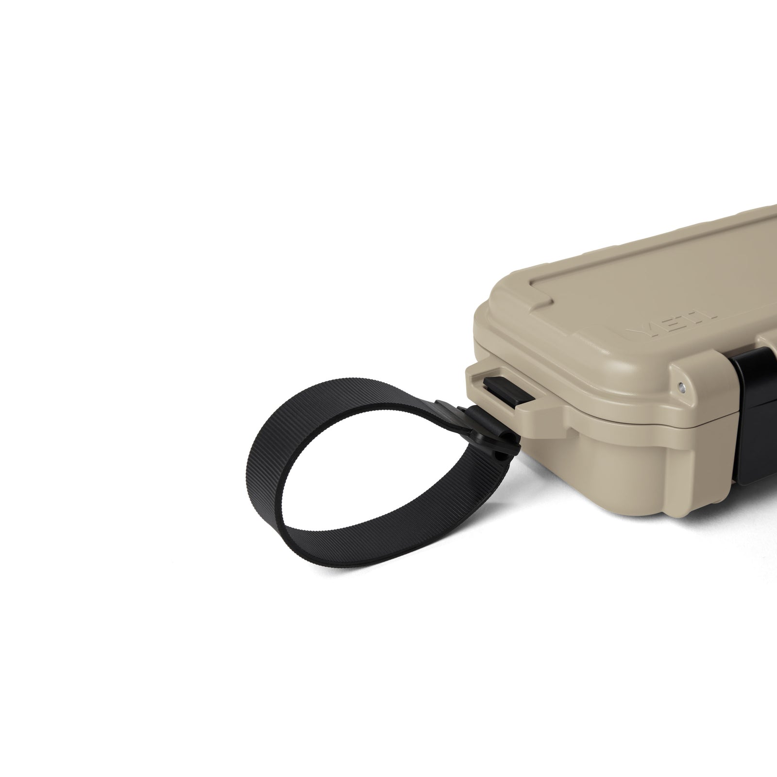 Eine hellbraune YETI® LoadOut GoBox 1 Ausrüstungsbox von YETI mit einer schwarzen Gurtschlaufe an einem Ende, dargestellt vor einem weißen Hintergrund.