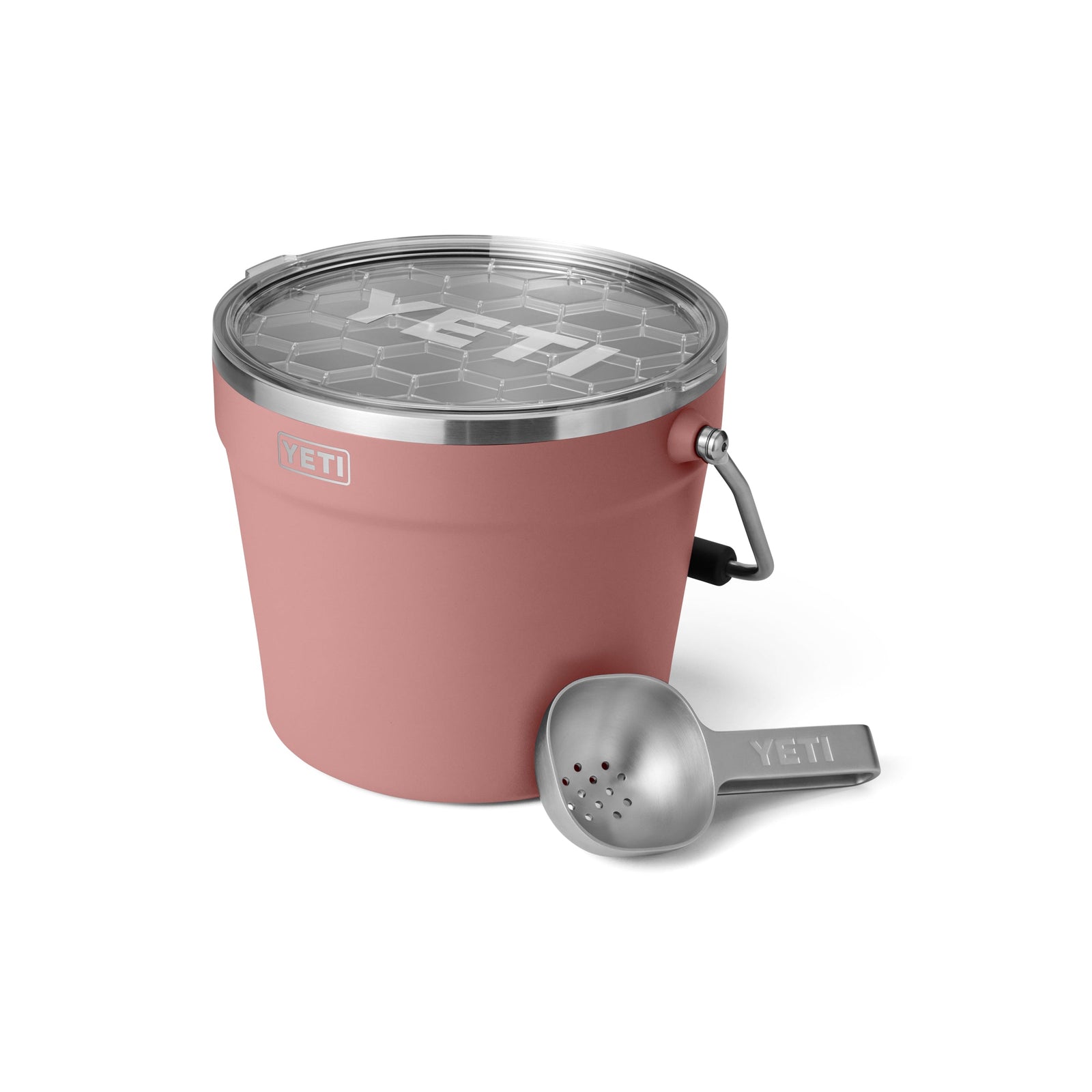 Der YETI® Rambler® 7,6 Liter Getränkekübel in Sandstone Pink mit durchsichtigem Deckel und Metallgriff hält Getränke kühl, hier neben einem silbernen YETI Eisportionierer.