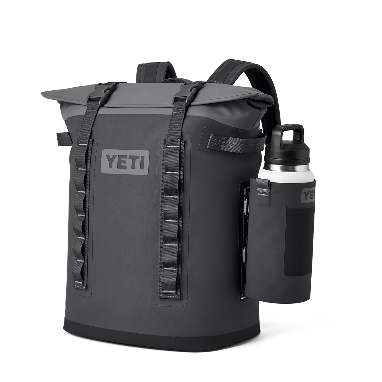 Ein grauer YETI-Rucksack mit Rolltop-Verschluss, zwei vertikalen Riemen auf der Vorderseite und einer seitlichen Halterung mit der YETI® Rambler Bottle Sling Large in Charcoal, die eine weiße YETI-Wasserflasche hält, wird vor einem schlichten weißen Hintergrund gezeigt.