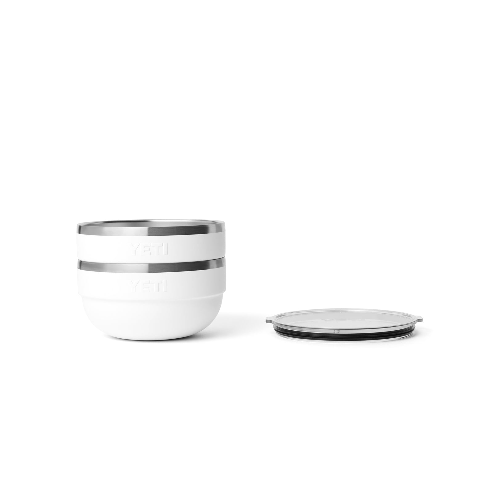 Zwei weiße YETI® Rambler Bowl Medium Schalen von YETI sind links gestapelt, aus rostfreiem Stahl, mit einem durchsichtigen Deckel flach auf der rechten Seite - alles vor einem weißen Hintergrund.