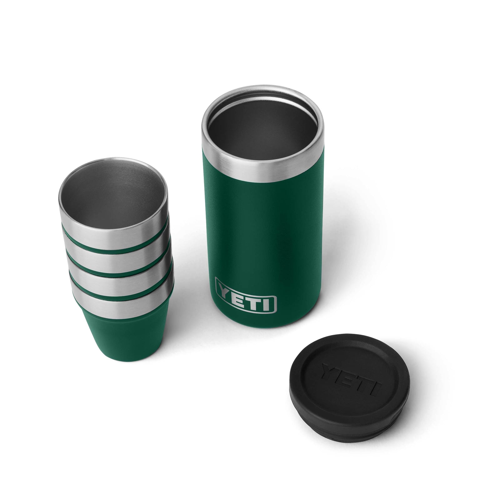 Ein YETI® Rambler Schnapsbecher in Black Forest Green mit schwarzem Deckel steht neben vier vakuumisolierten Edelstahlbechern, die alle auf einem weißen Hintergrund abgebildet sind.
