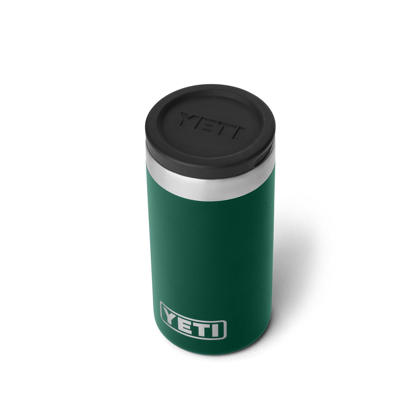 Ein YETI® Rambler Schnapsbecher in Black Forest Green mit schwarzem Deckel und Edelstahlverzierung steht auf weißem Hintergrund und zeigt das YETI-Logo auf der Vorderseite.