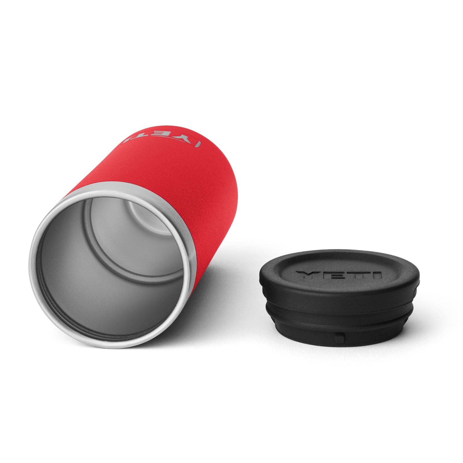 Ein YETI® Rambler Schnapsbecher in Rescue Red liegt auf der Seite neben einem schwarzen Sicherheitsdeckel, beide auf weißem Hintergrund.