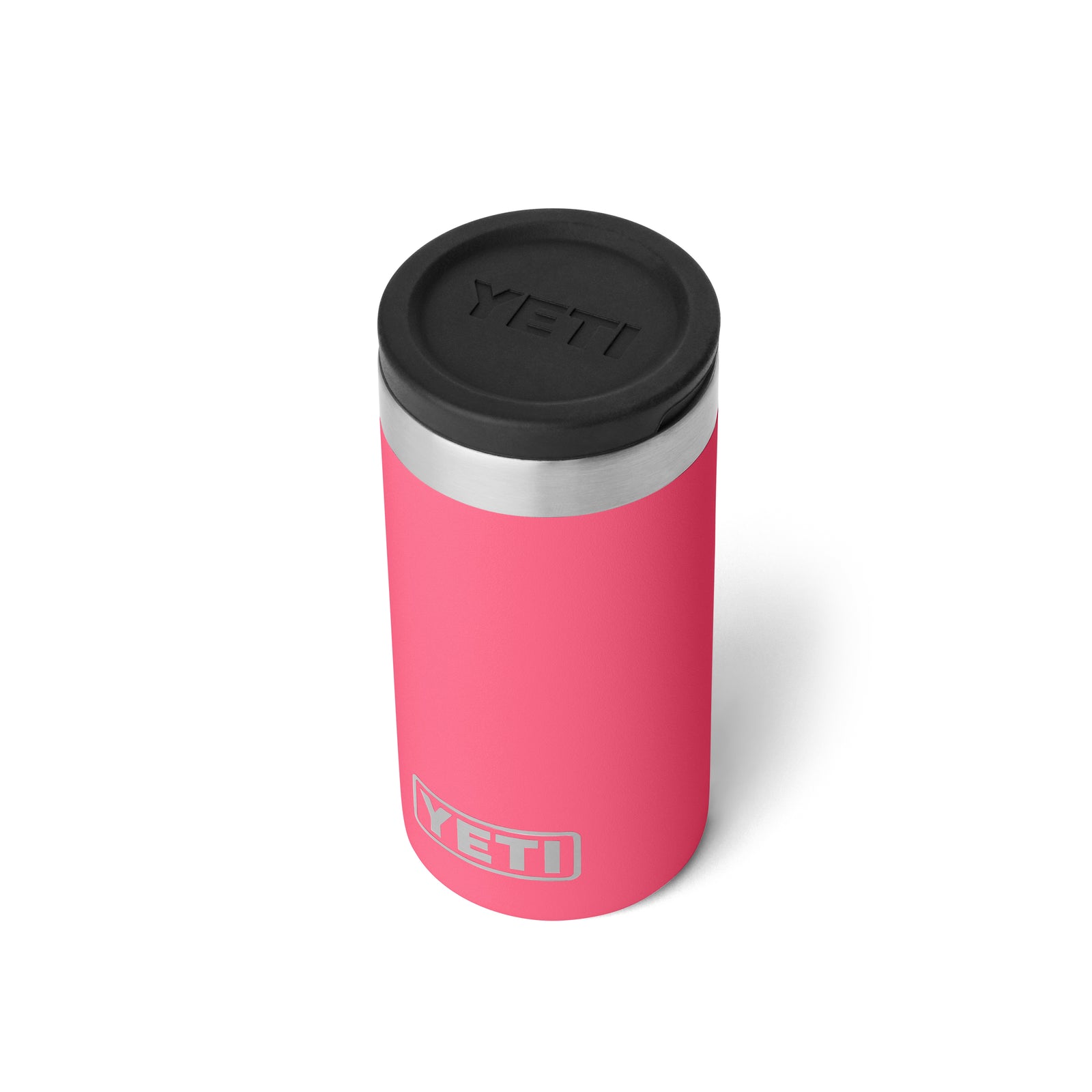 Ein YETI® Rambler Schnapsbecher in Tropical Pink steht mit schwarzem Deckel und silbernem Rand aufrecht vor weißem Hintergrund. Das weiße und graue YETI Logo ziert den vakuumisolierten Edelstahlbecher am unteren Rand.