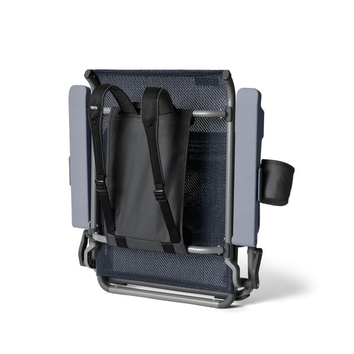 Die YETI® Rückengurte für den Strandstuhl ist ein tragbarer Klappstuhl mit Netzrücken, grauem Rahmen, integriertem Becherhalter und rucksackähnlichen Gurten für den einfachen Transport.