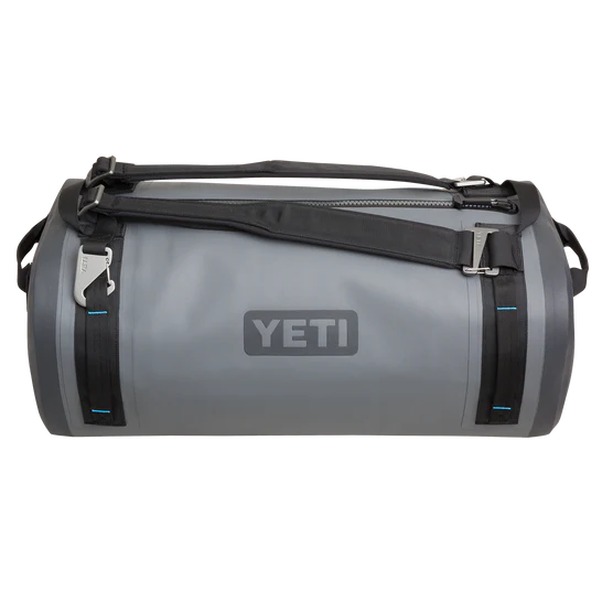 Die YETI® Reisetasche Panga 50 - Storm Grey ist eine zylindrische graue Reisetasche mit schwarzen Trägern, blauen Nähten und einem Reißverschluss an der Oberseite, abgebildet auf einem schlichten weißen Hintergrund.