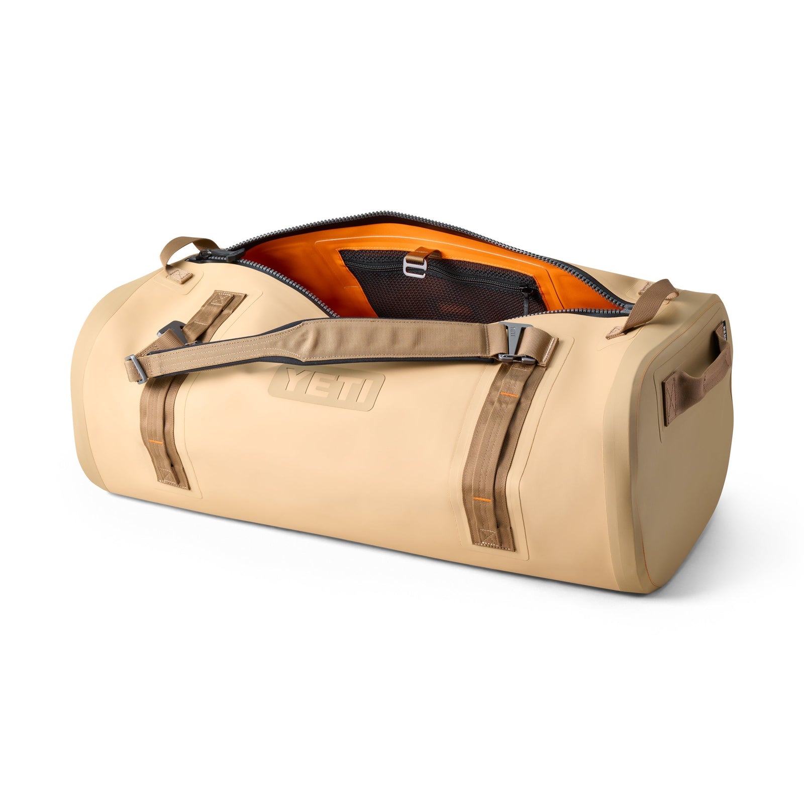 Die YETI® Reisetasche Panga 75 - Tan von YETI ist geöffnet und zeigt ein orangefarbenes Innenfutter sowie eine schwarze Mesh-Tasche mit Schnalle-ideal für jedes Outdoor-Abenteuer.
