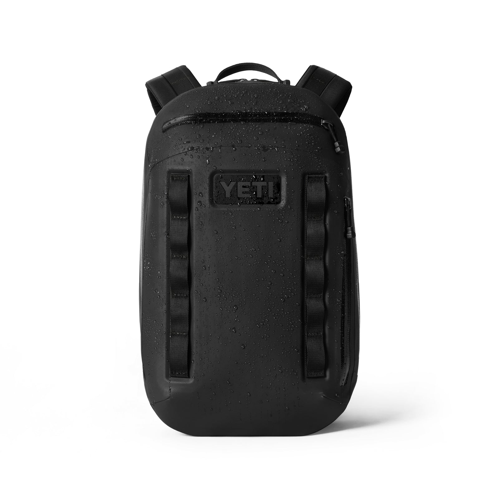 Der YETI® Rucksack Cayo™ 15L in Schwarz steht aufrecht mit Wassertropfen und präsentiert sein wasserfestes Design, gepolsterte Schultergurte und mehrere Reißverschlussfächer für organisierte Aufbewahrung.