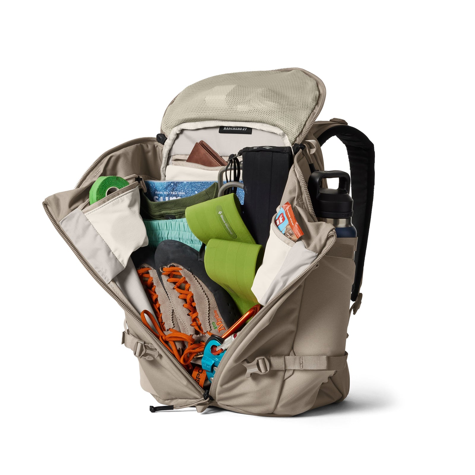 Ein YETI® Rucksack Ranchero™ 27L in Cape Dark Taupe wird aufgeklappt und zeigt organisierte Innentaschen mit Wanderausrüstung: Kletterschuhe, grüne Matte, Wasserflasche, blauer Beutel, schwarze Tasche, Snacks und ein aufgerolltes Seil.