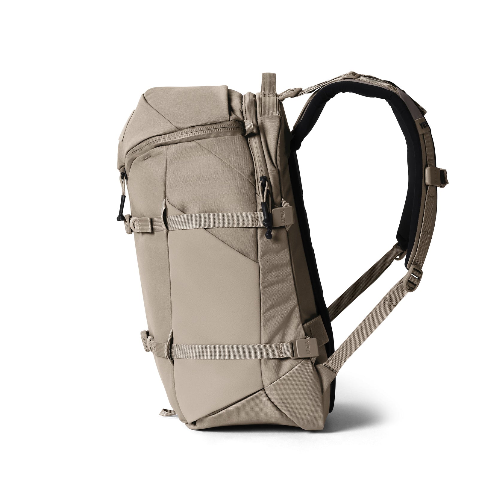 Der YETI® Rucksack Ranchero™ 27L in Cape Dark Taupe ist ein moderner Rucksack mit gepolsterten Schultergurten, mehreren verstellbaren Schnallen und geometrischen Nähten, der aufrecht auf weißem Hintergrund steht.
