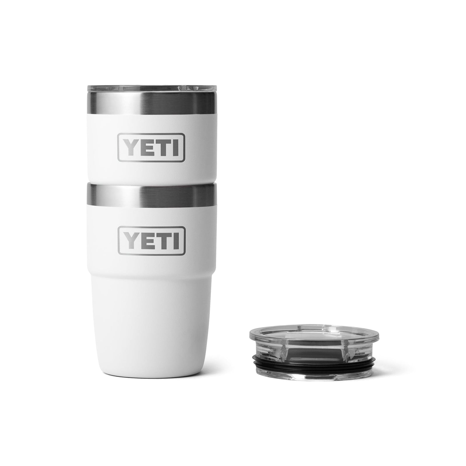 Zwei YETI® Stapelbarer Becher Rambler 8 Oz in Weiß sind gestapelt, mit einem klaren Deckel daneben. Die vakuumisolierten YETI-Becher sind auf einem einfarbig weißen Hintergrund abgebildet.